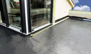 Nowy balkon z profesjonalną hydroizolacją. Czarna membrana zabezpiecza przed wilgocią, a żółta taśma uszczelnia połączenie ze stolarką okienną.