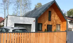 Nowoczesna dobudówka do domu bez pozwolenia, z drewnianą elewacją i garażem.