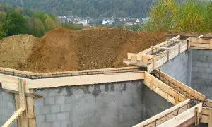 Fundamenty domu w budowie, zbrojenie i szalunki gotowe do zalania betonem. To pierwszy krok do pozwolenia na budowę.