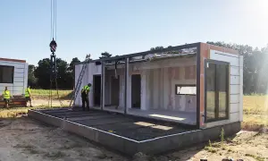 Budowa modułowego domu w toku. Po zgłoszeniu i uzyskaniu pozwolenia na budowę, montaż ścian i konstrukcji trwa.