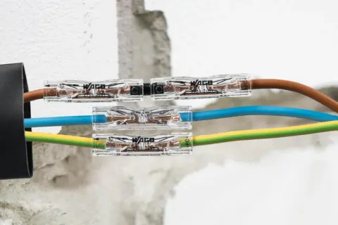 Jak połączyć przecięty kabel w ścianie? Szybkie i bezpieczne połączenie przewodów brązowego, niebieskiego i żółto-zielonego za pomocą złączek WAGO.