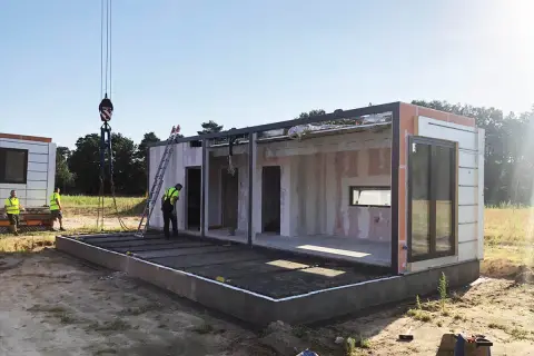Budowa modułowego domu w toku. Po zgłoszeniu i uzyskaniu pozwolenia na budowę, montaż ścian i konstrukcji trwa.