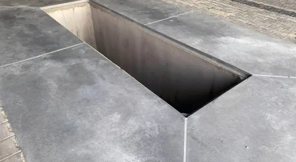 Betonowy kanał samochodowy, widoczna jego szerokość i głębokość.
