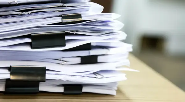 Stos dokumentów, wśród których może kryć się zgubiony projekt domu.