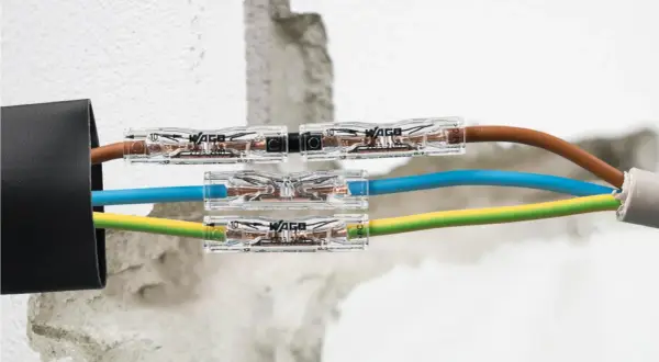 Jak połączyć przecięty kabel w ścianie? Szybkie i bezpieczne połączenie przewodów brązowego, niebieskiego i żółto-zielonego za pomocą złączek WAGO.