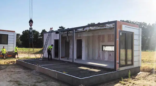 Budowa modułowego domu w toku. Po zgłoszeniu i uzyskaniu pozwolenia na budowę, montaż ścian i konstrukcji trwa.