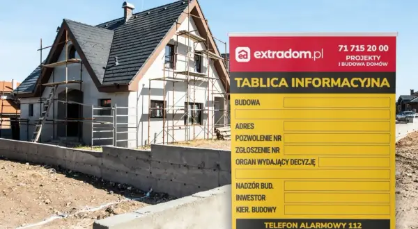 Tablica informacyjna budowy z danymi kontaktowymi i numerami alarmowymi, obok dom w trakcie budowy. RODO na budowie.
