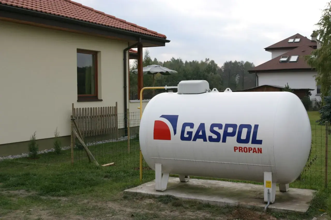 Duży zbiornik na propan marki GASPOL, zapewniający ogrzewanie LPG dla domu.