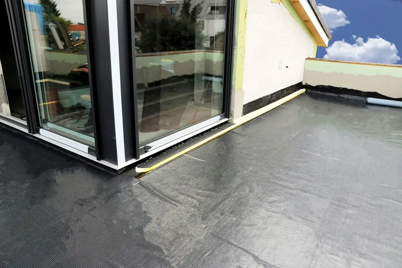 Nowy balkon z profesjonalną hydroizolacją. Czarna membrana zabezpiecza przed wilgocią, a ż&oacute;łta taśma uszczelnia połączenie ze stolarką okienną.