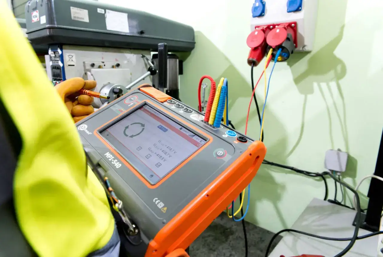 Elektryk dokonuje pomiar&oacute;w do protokołu odbioru instalacji elektrycznej za pomocą miernika MPI-540.