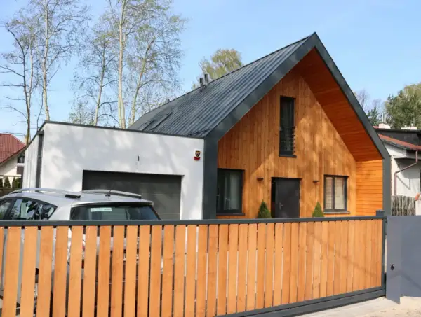 Nowoczesna dobudówka do domu bez pozwolenia, z drewnianą elewacją i garażem.
